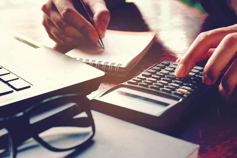 Person uses calculator while reviewing contracts and determining what to look for.