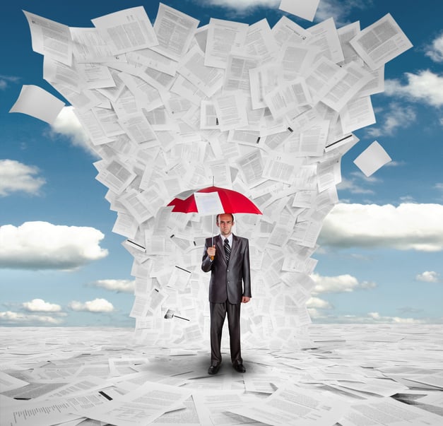 Man holds an umbrella against deluge of documents to illustrate the scope of contract risk management